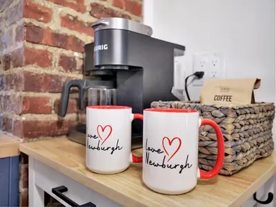 two coffee mugs with hearts on them sitting on a counter at Deck View of Hudson River & Mt Beacon / Boho Suite in Newburgh