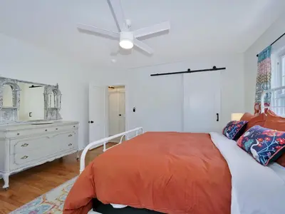 a white bedroom with a bed and a white dresser at Deck View of Hudson River & Mt Beacon / Boho Suite in Newburgh