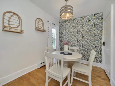 a dining room with a white table and chairs at Deck View of Hudson River & Mt Beacon / Boho Suite in Newburgh