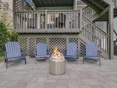 a fire pit on a patio with chairs and a balcony at Deck View of Hudson River & Mt Beacon / Boho Suite in Newburgh
