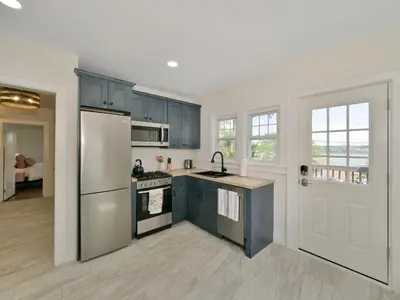 a kitchen with blue cabinets and a refrigerator at Deck View of Hudson River & Mt Beacon / Boho Suite in Newburgh