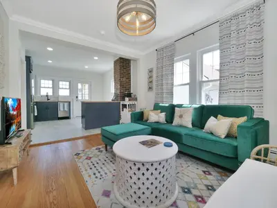 a living room with a green couch and a tv at Deck View of Hudson River & Mt Beacon / Boho Suite in Newburgh