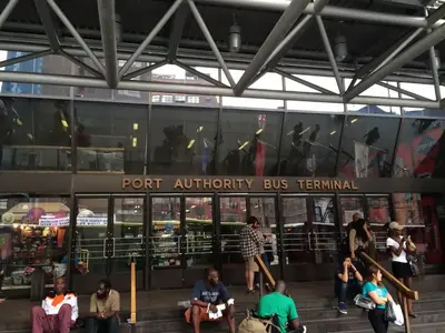 a group of people sitting in front of a port authority bus terminal at Warm 3 BR for U Near Manhattan View, 15 Min to NYC in West New York