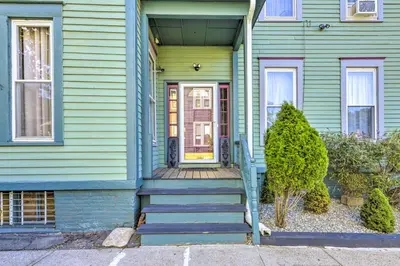 a green house with stairs leading to the front door at Charming Springfield Apt Less Than 2 Mi to Downtown! in Springfield
