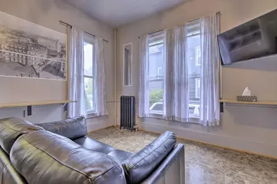 a living room with a leather couch and a window at Charming Springfield Apt Less Than 2 Mi to Downtown! in Springfield