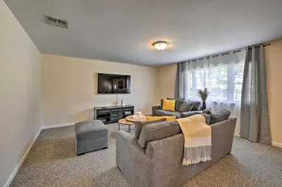 a living room with a couch and a tv at Glen Cove Home Walk to Boardwalk and Dining! in Glen Cove