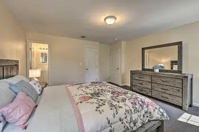 a bedroom with a bed with a dresser and a mirror at Glen Cove Home Walk to Boardwalk and Dining! in Glen Cove