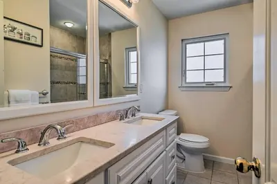 a bathroom with two sinks and a toilet at Glen Cove Home Walk to Boardwalk and Dining! in Glen Cove