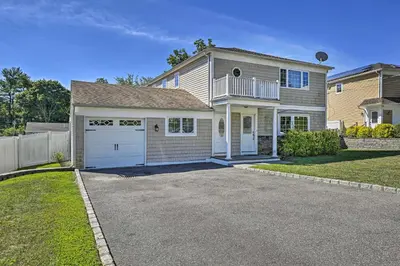 a large house with a garage on a driveway at Glen Cove Home Walk to Boardwalk and Dining! in Glen Cove