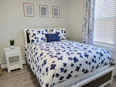 a bedroom with a bed with a blue and white comforter at 1 Bedroom apartment in Hartford