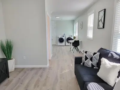 a living room with a black couch and a kitchen at 1 Bedroom apartment in Hartford