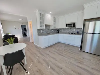 a kitchen with white cabinets and a table and a refrigerator at 1 Bedroom apartment in Hartford