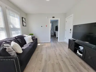 a living room with a black couch and a flat screen tv at 1 Bedroom apartment in Hartford