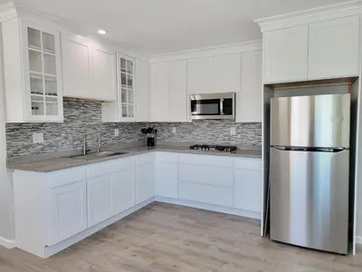 a kitchen with white cabinets and a stainless steel refrigerator at 1 Bedroom apartment in Hartford