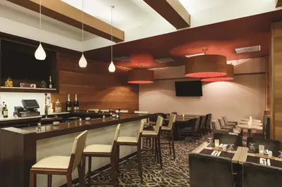 a restaurant with a bar and a bunch of chairs at Hilton Garden Inn New York Manhattan Midtown East in New York