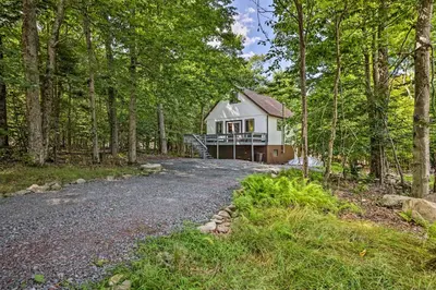 a house in the woods with a gravel road at Chic Tobyhanna Home with Furnished Deck Space! in Tobyhanna