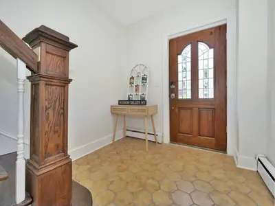a hallway with a wooden door and a table in front of it at MidCentury Mod Suite, Hudson River/Mt Beacon Views in Newburgh