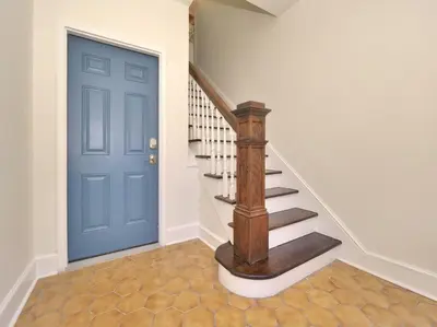 a hallway with a blue door and a staircase at MidCentury Mod Suite, Hudson River/Mt Beacon Views in Newburgh
