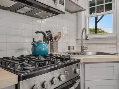 a kitchen with a stove with a blue tea pot on it at MidCentury Mod Suite, Hudson River/Mt Beacon Views in Newburgh