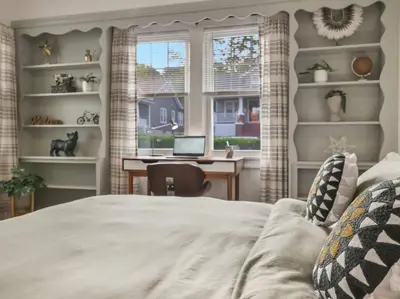 a bedroom with a bed and a desk with a laptop at MidCentury Mod Suite, Hudson River/Mt Beacon Views in Newburgh
