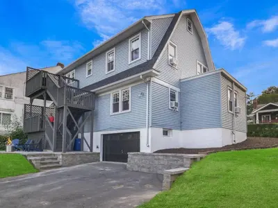 a large house with a staircase in front of it at MidCentury Mod Suite, Hudson River/Mt Beacon Views in Newburgh