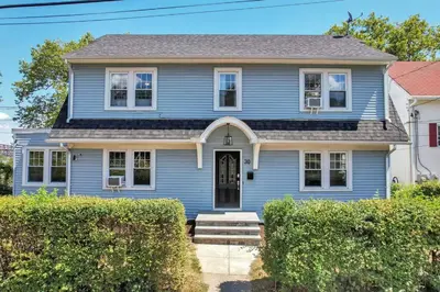 a blue house with bushes in front of it at MidCentury Mod Suite, Hudson River/Mt Beacon Views in Newburgh