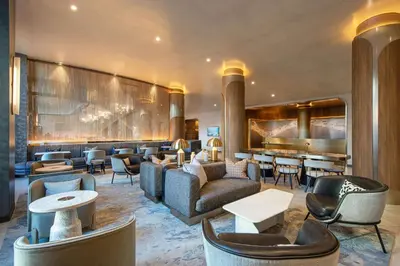 a hotel lobby with couches and tables and a bar at Hilton New York Times Square in New York