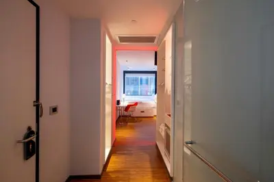 a hallway with a hallway leading to a room with a table at citizenM New York Times Square in New York