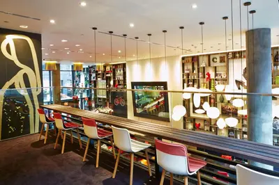 a bar with red and white chairs in a restaurant at citizenM New York Times Square in New York