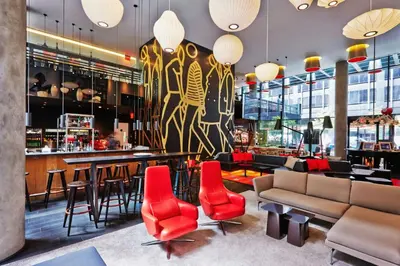 a restaurant with red chairs and a bar at citizenM New York Times Square in New York