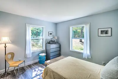 a bedroom with two windows and a bed and a chair at Peaceful Athens Retreat at Sleepy Hollow Lake in Athens