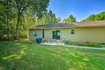 a yellow house with a patio in the yard at Peaceful Athens Retreat at Sleepy Hollow Lake in Athens