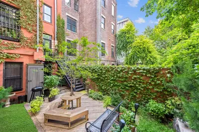 a garden with a table and benches in front of a building at Home NYC in New York