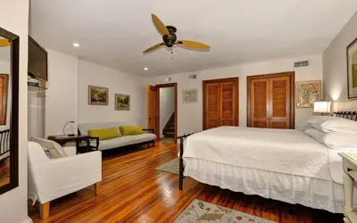 a bedroom with a bed and a couch and a ceiling fan at Home NYC in New York