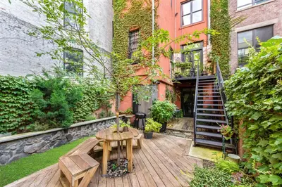 a wooden deck with a table and bench in front of a building at Home NYC in New York
