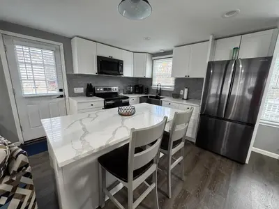 a kitchen with a white counter and a refrigerator at Casa Rosado @ Pocono II by Lake Hot Tub Camelback in Tobyhanna