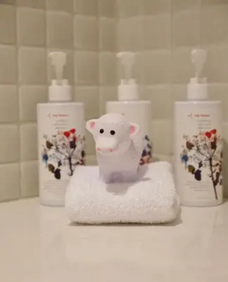 a toy lamb sitting on top of a pile of towels at Virgin Hotels New York City in New York