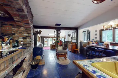 a living room with a brick wall and a kitchen at Hoot Owl Hollow in Jacksonville