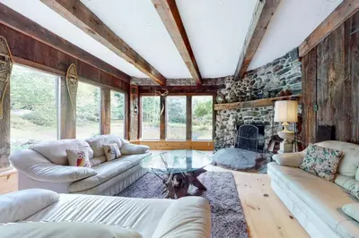 a living room with couches and a stone wall at Hoot Owl Hollow in Jacksonville