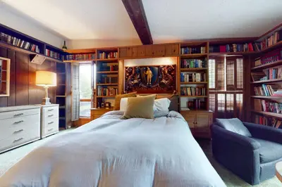 a bedroom with a large bed and bookshelves at Hoot Owl Hollow in Jacksonville