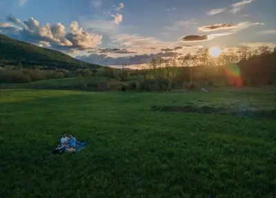 two people sitting in the grass in a field at Hotel Vienna in Windham