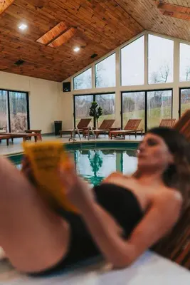 a woman laying in front of a swimming pool at Hotel Vienna in Windham