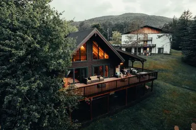 a large wooden house with a large deck at Hotel Vienna in Windham