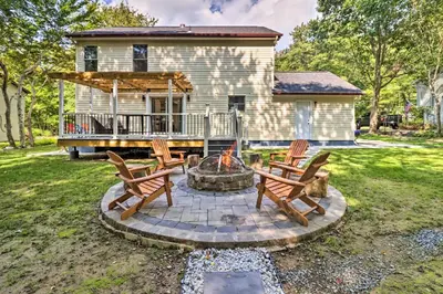 a backyard with two chairs and a fire pit at Game Room and Yard Family Paradise in Pocono Summit in Pocono Summit Estates
