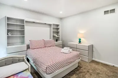 a white bedroom with a bed and a night stand at Game Room and Yard Family Paradise in Pocono Summit in Pocono Summit Estates