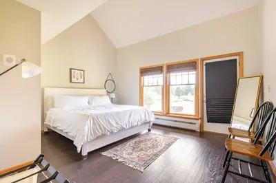 a white bedroom with a bed and a window at Beautiful mountain home with gorgeous meadow views in Hunter