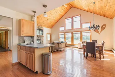 a kitchen and living room with a table and a dining room at Beautiful mountain home with gorgeous meadow views in Hunter