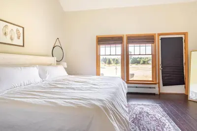 a bedroom with a white bed and a window at Beautiful mountain home with gorgeous meadow views in Hunter