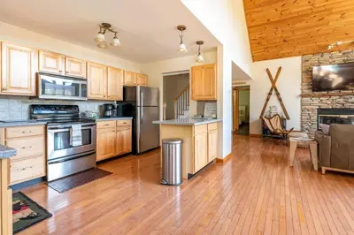 a large kitchen with wooden cabinets and stainless steel appliances at Beautiful mountain home with gorgeous meadow views in Hunter