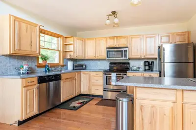 a kitchen with wooden cabinets and stainless steel appliances at Beautiful mountain home with gorgeous meadow views in Hunter